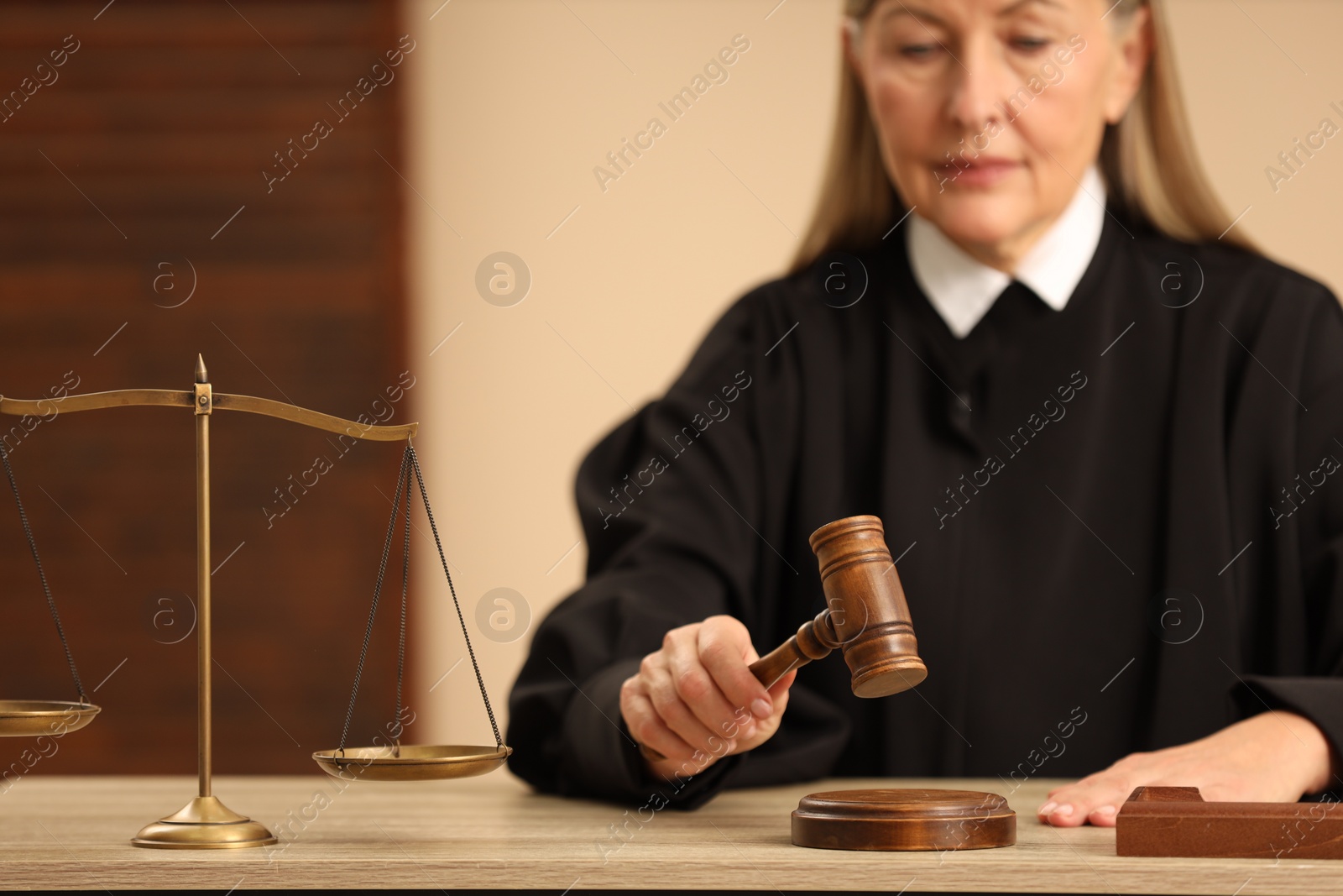 Photo of Judge striking mallet at wooden table indoors, selective focus