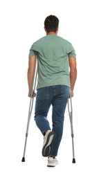Young man with axillary crutches on white background, back view