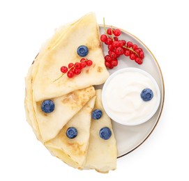 Delicious crepes with natural yogurt, blueberries and red currants on white background