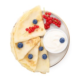 Photo of Delicious crepes with natural yogurt, blueberries and red currants on white background