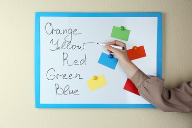 Photo of Woman matching colors on white board, closeup. ABA therapy concept