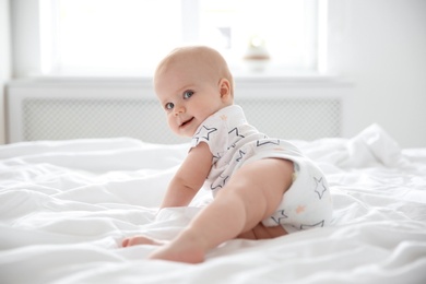 Cute little baby crawling on bed at home