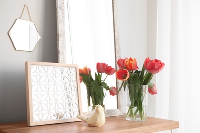 Photo of Modern room interior with mirror and flowers on table