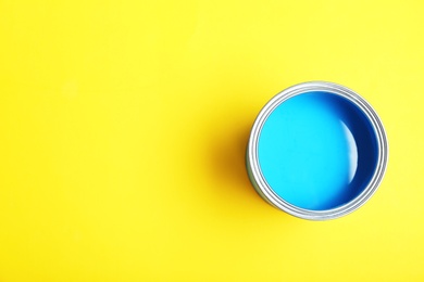 Photo of Paint can on yellow background, top view. Space for text