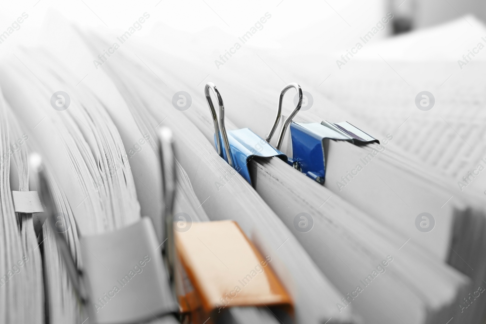Photo of Pile of documents with colorful binder clips
