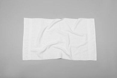 Photo of Crumpled white beach towel on light grey background, top view