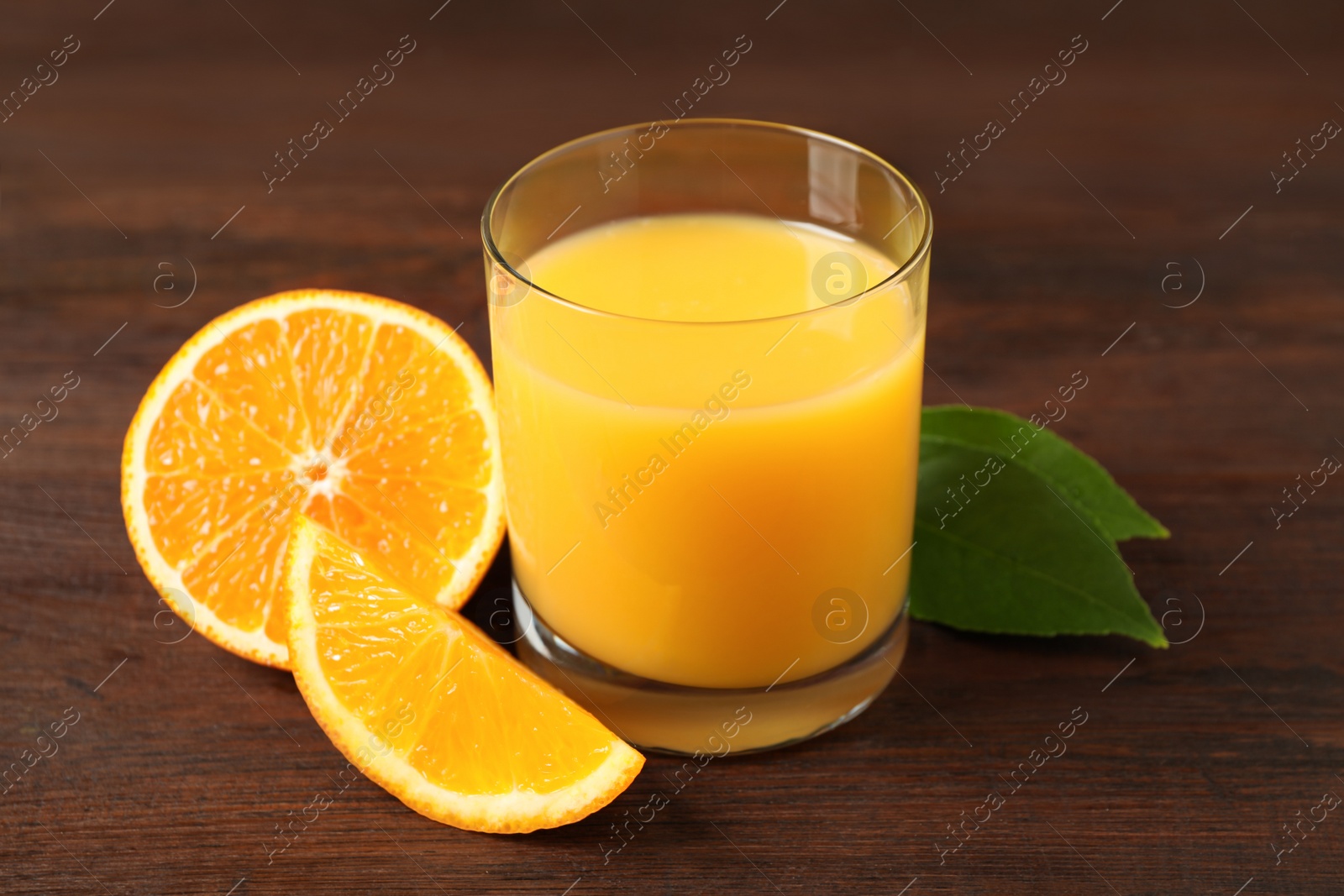 Photo of Glass of orange juice and fresh fruits on wooden table, closeup