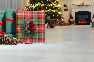 Photo of Beautiful gift boxes near Christmas tree in room, space for text