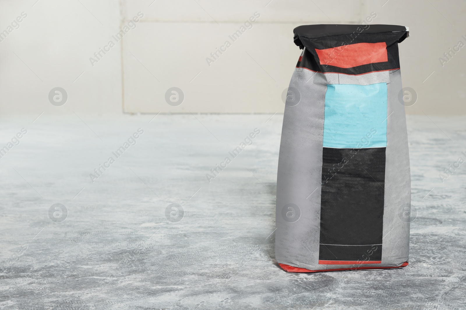 Photo of Cement powder in bag on stone floor. Space for text