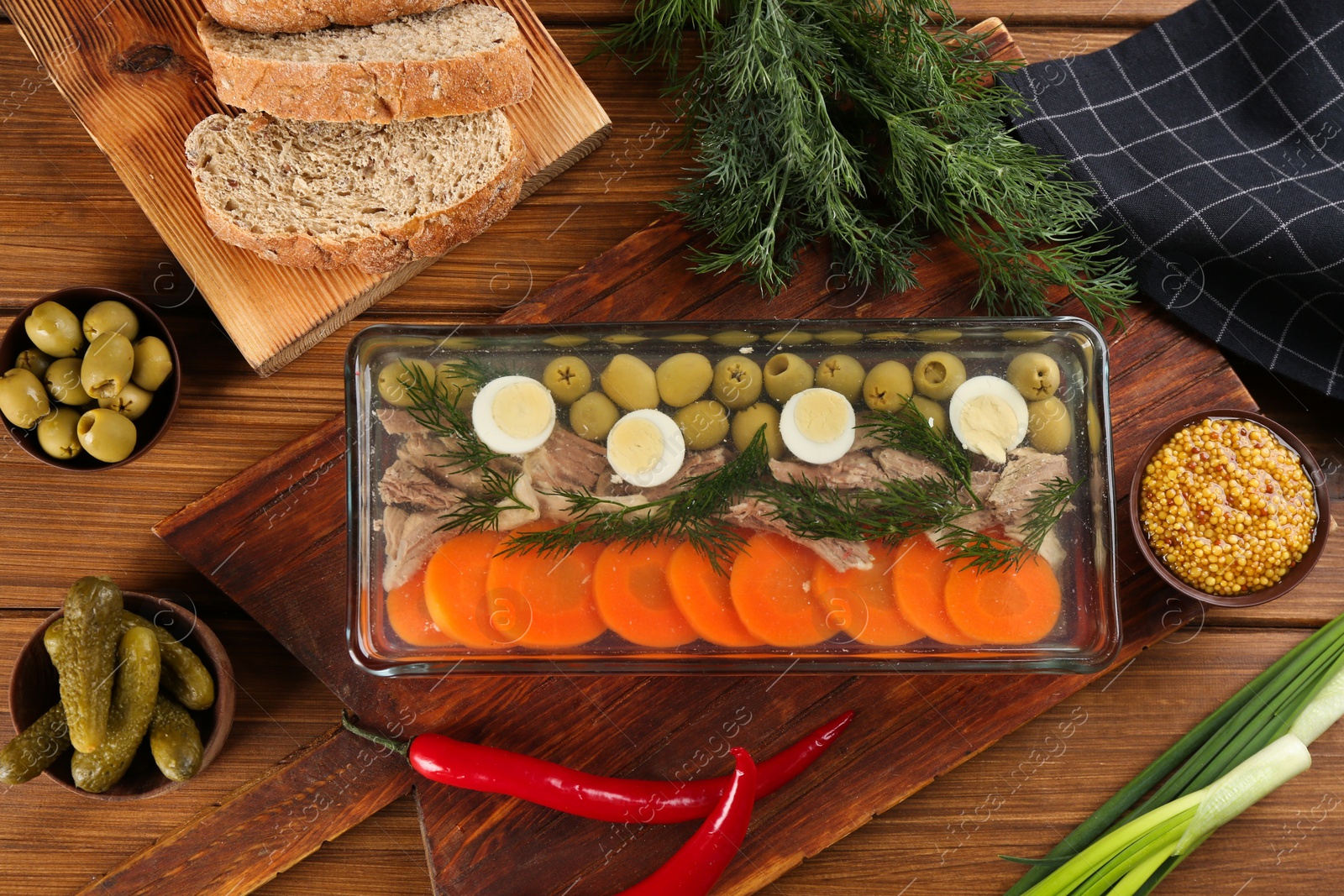 Photo of Delicious aspic with meat and vegetables served on wooden table, flat lay