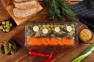 Delicious aspic with meat and vegetables served on wooden table, flat lay