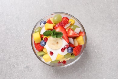 Photo of Delicious fruit salad on light grey table, top view