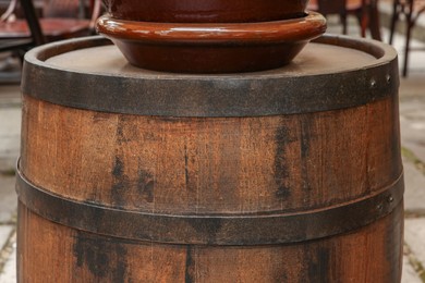 Photo of Traditional wooden barrel outdoors, closeup. Wine making