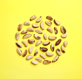 Flat lay composition with Brazil nuts on color background