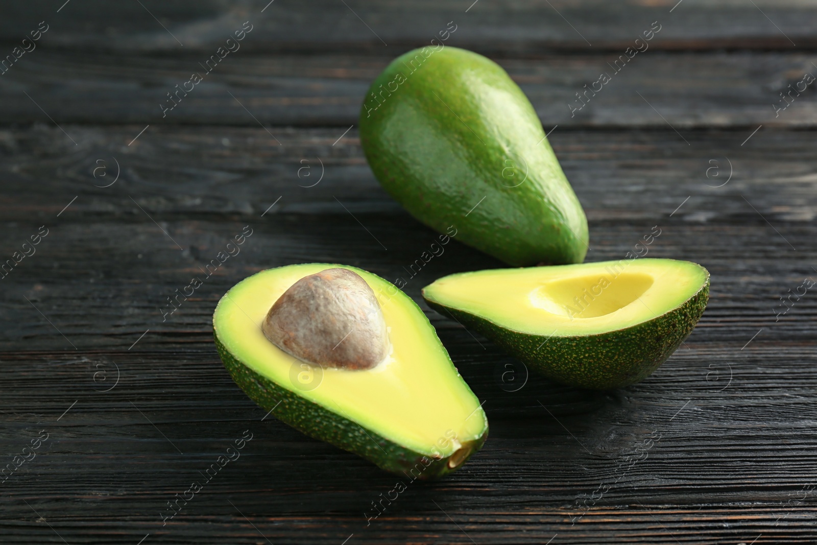 Photo of Tasty ripe green avocados on wooden background