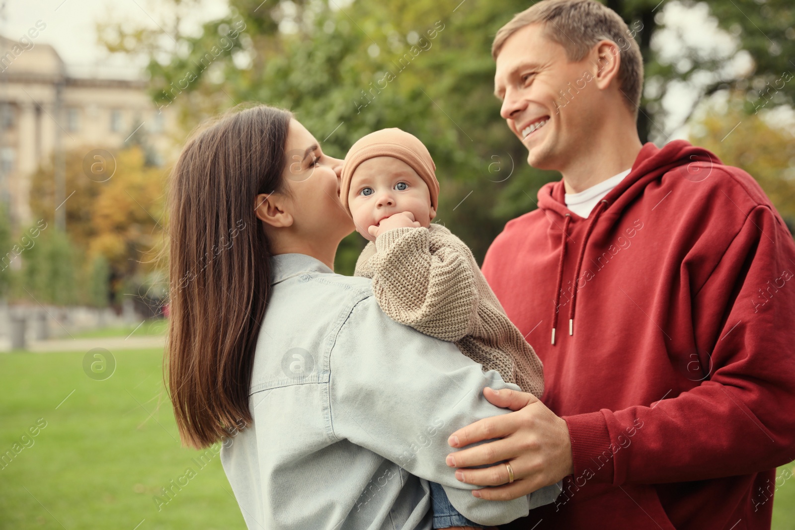 Photo of Happy parents with their adorable baby walking in park