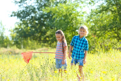Photo of Cute little children with butterfly net outdoors. Spending time in nature