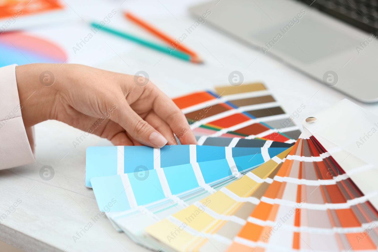 Photo of Woman with paint color palette samples at table, closeup