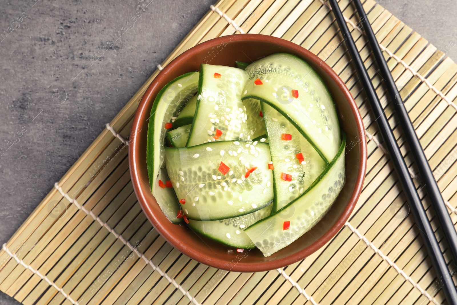 Photo of Dish with fresh cucumber salad served on table, top view