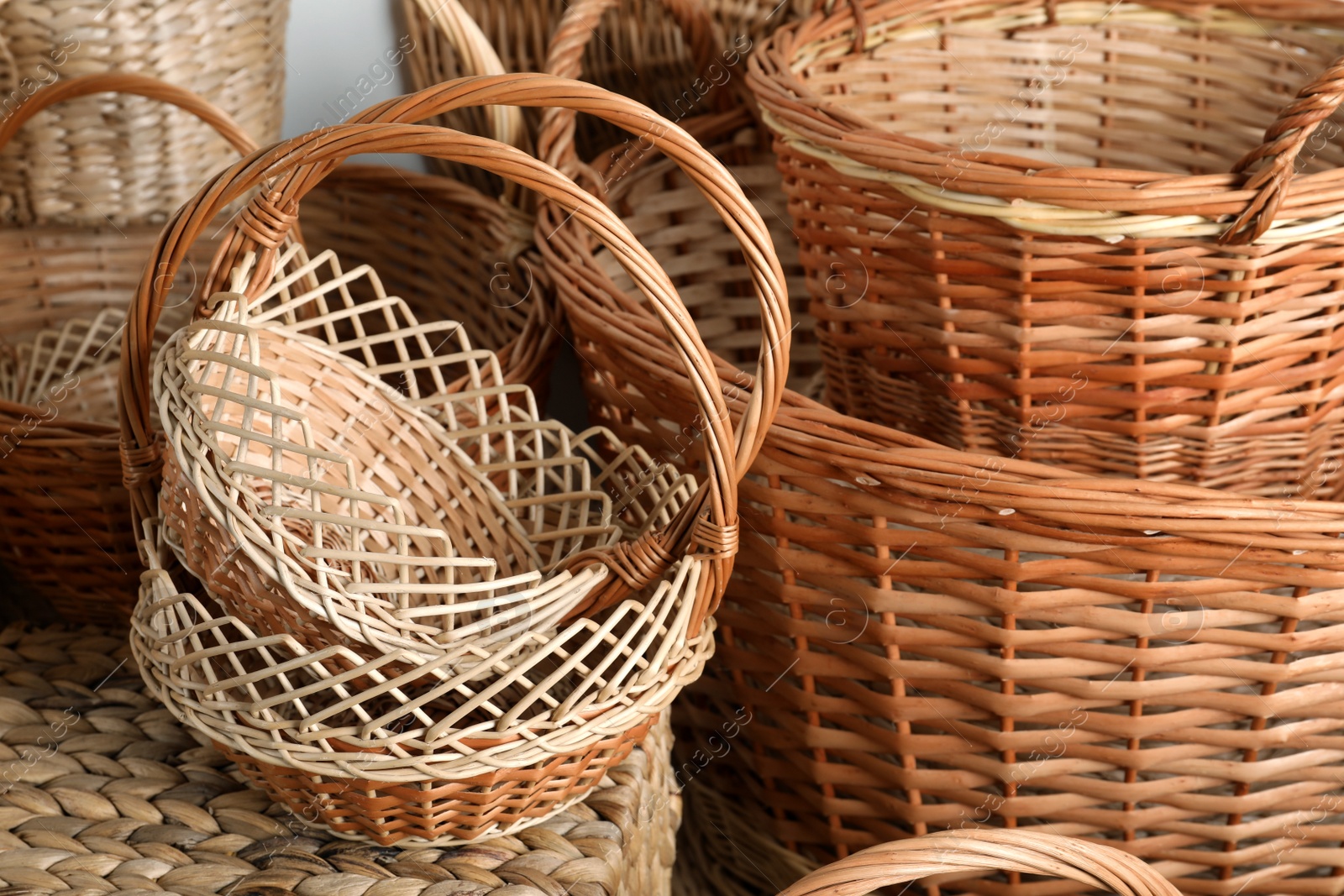 Photo of Many different wicker baskets made of natural material as background, closeup