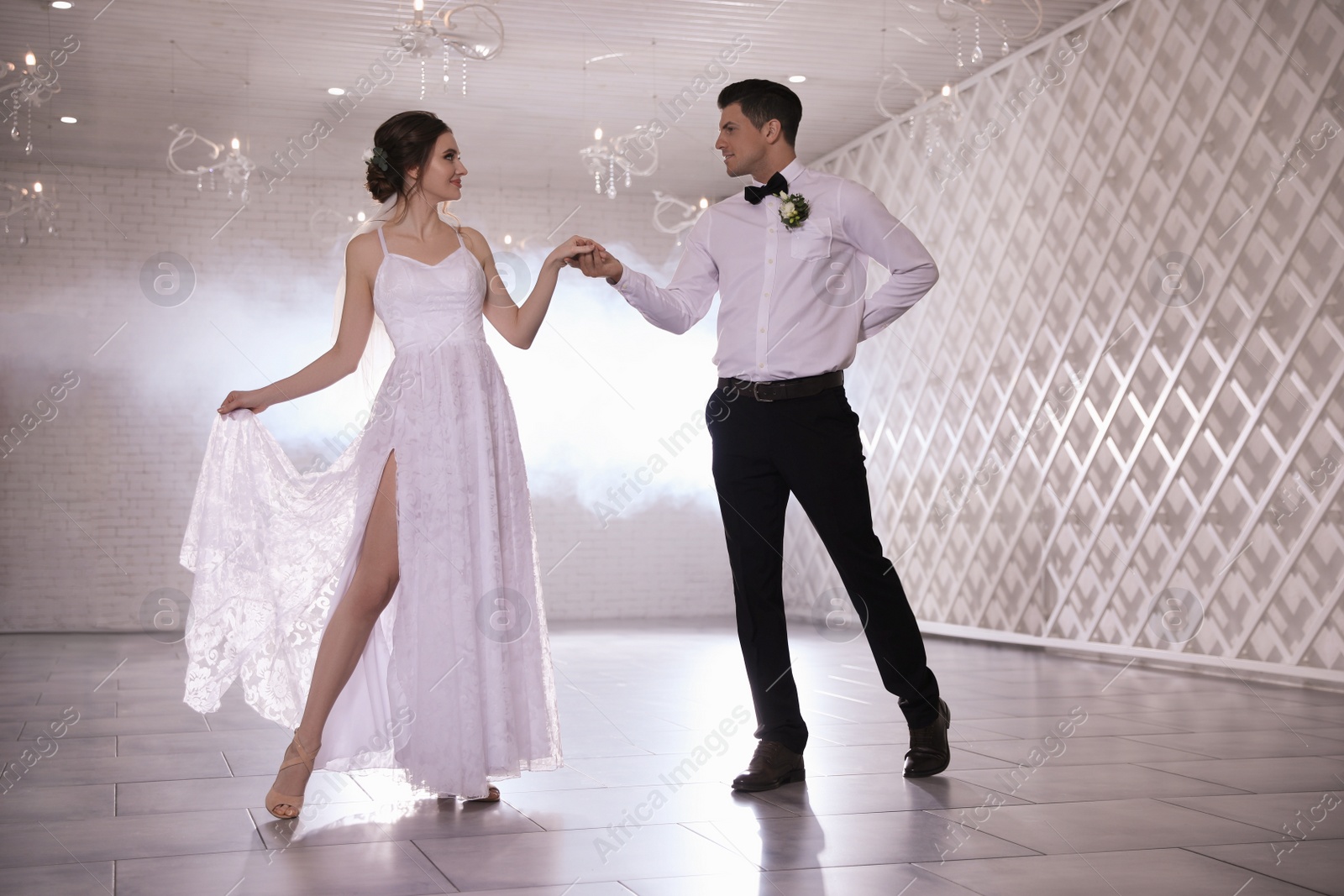 Photo of Happy newlywed couple dancing together in festive hall