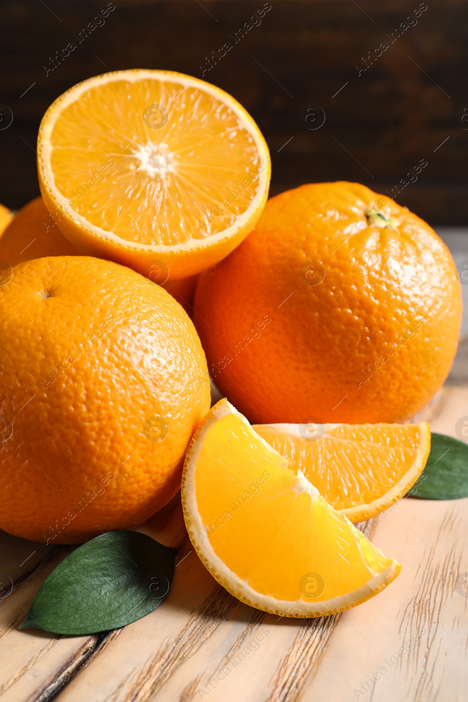 Photo of Fresh oranges with leaves on wooden table