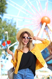 Beautiful woman with candies having fun at amusement park