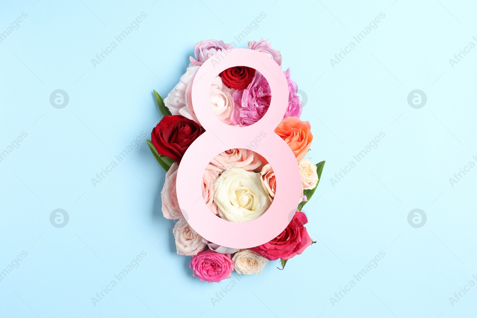 Photo of 8 March greeting card design with beautiful roses on light blue background, top view