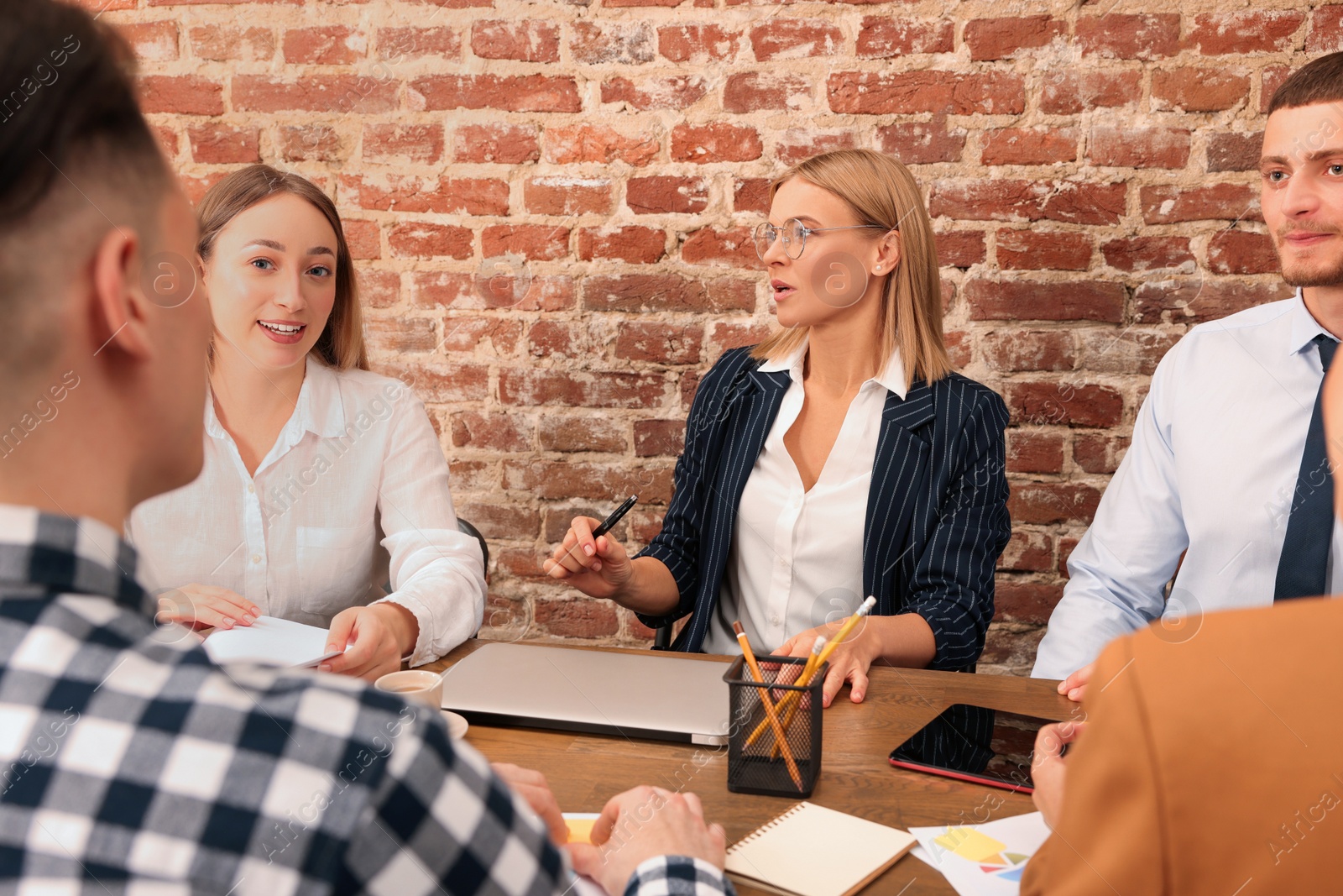 Photo of Businesswoman having meeting with her employees in office. Lady boss