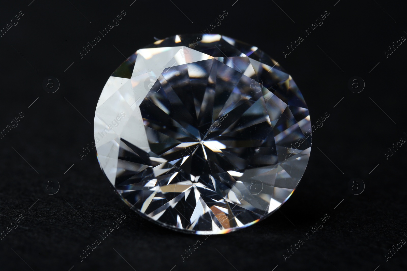 Photo of Beautiful shiny diamond on black background, closeup