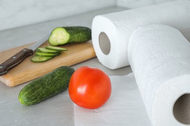 Paper towels and fresh vegetables on kitchen table