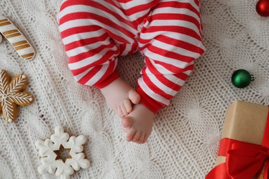 Photo of Cute little baby and Christmas decorations on blanket, top view