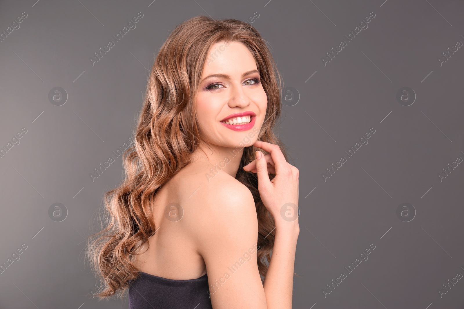 Photo of Portrait of young woman with long beautiful hair on grey background