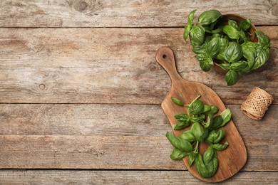 Photo of Flat lay composition with fresh basil on wooden background. Space for text