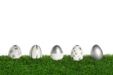 Photo of Line of painted Easter eggs on green lawn against white background