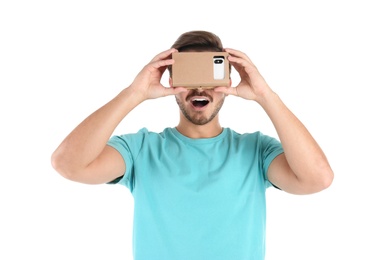 Young man using cardboard virtual reality headset, isolated on white