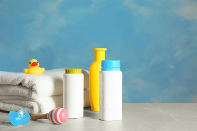 Set of different baby accessories on table against color background