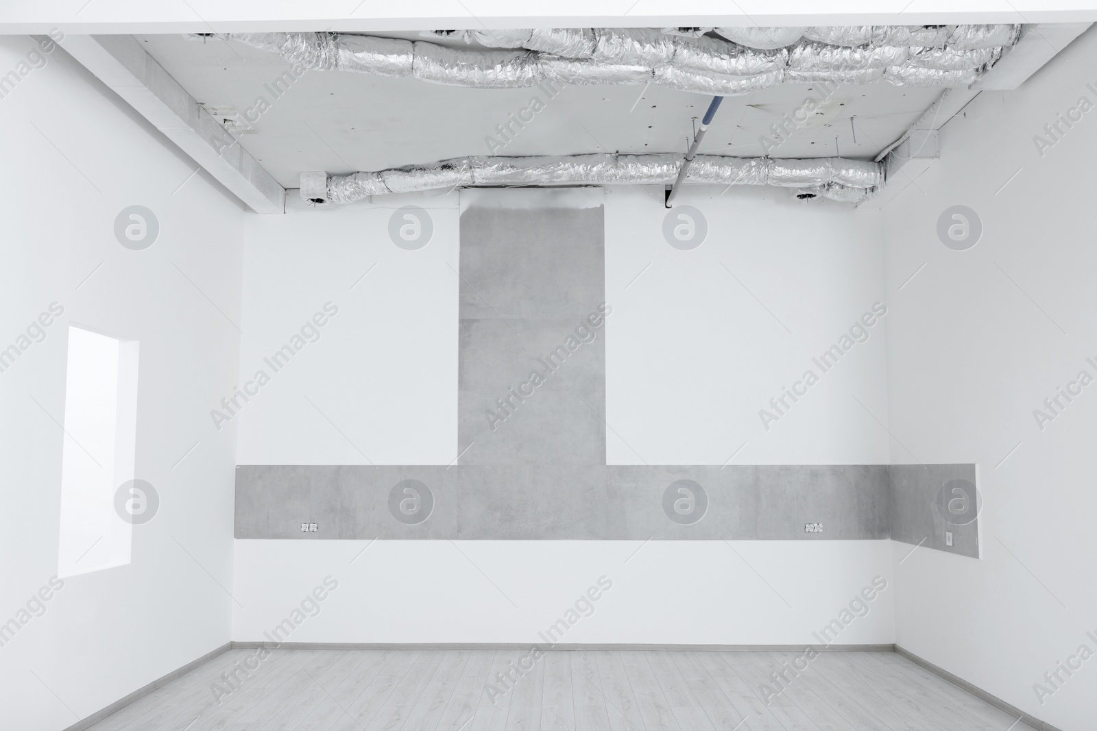 Photo of Empty room with white walls, sockets and ventilation system during repair