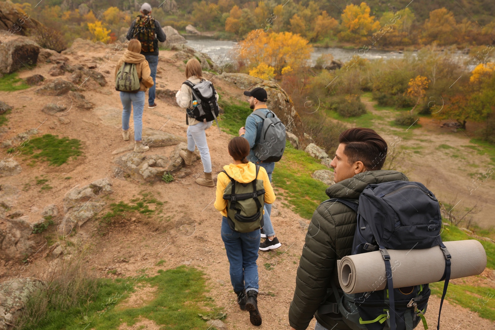 Photo of Group of hikers with backpacks climbing up mountains