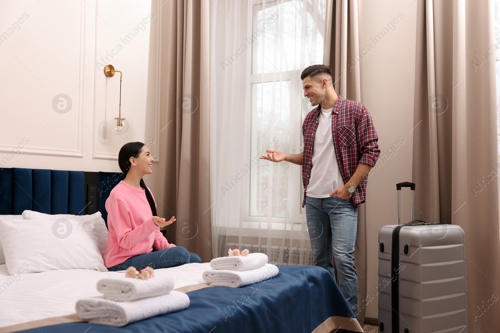 Photo of Happy couple having conversation in hotel room