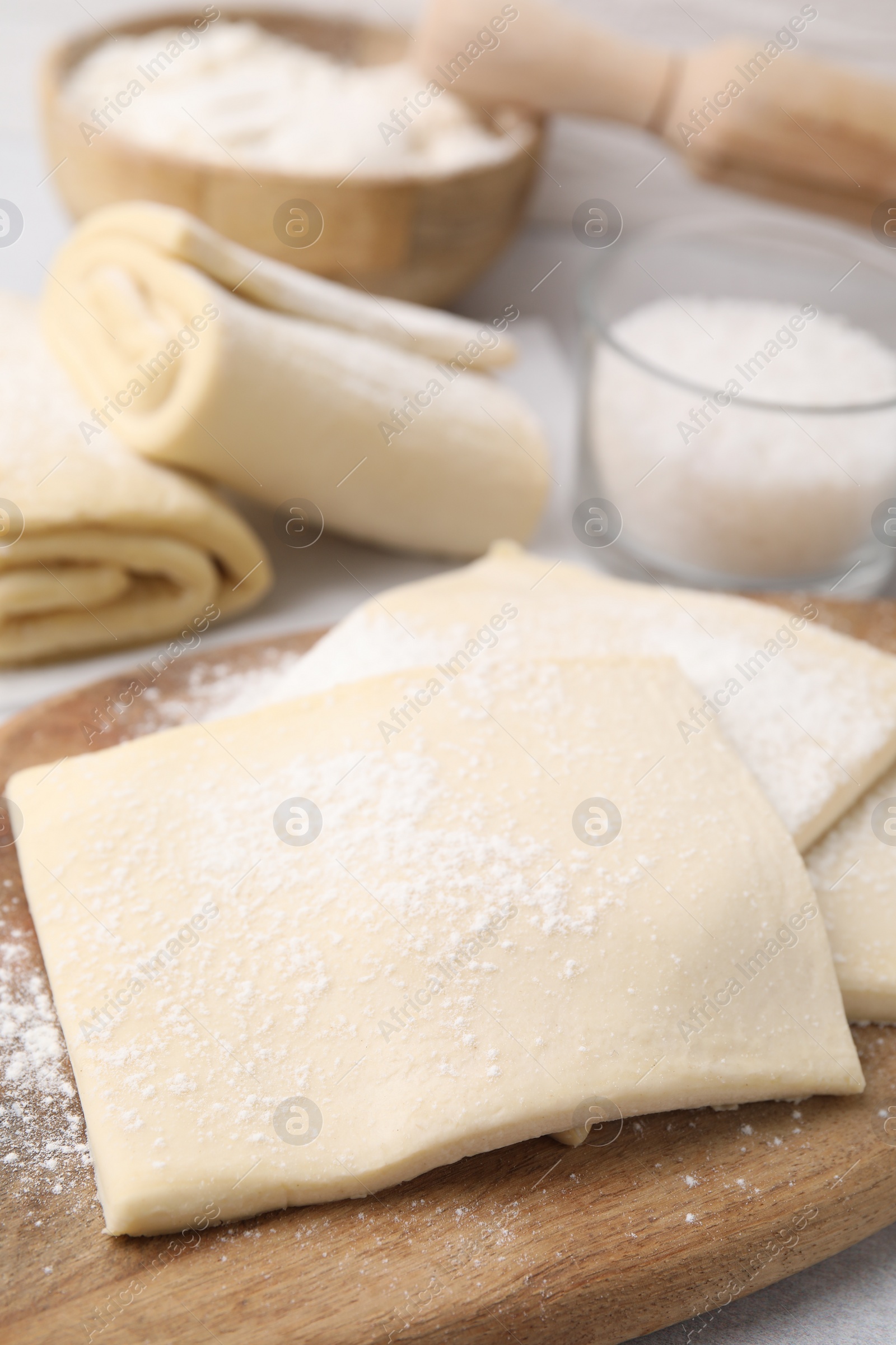 Photo of Raw puff pastry dough on table, closeup