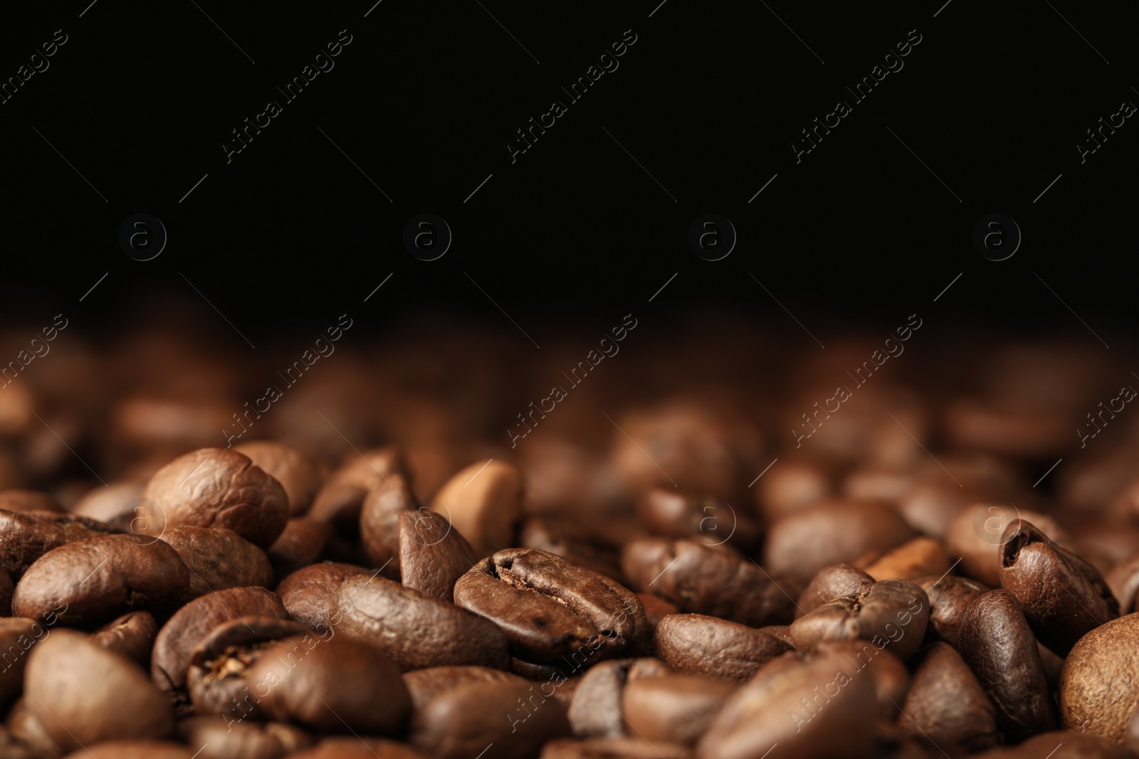 Photo of Many roasted coffee beans on black background, closeup. Space for text