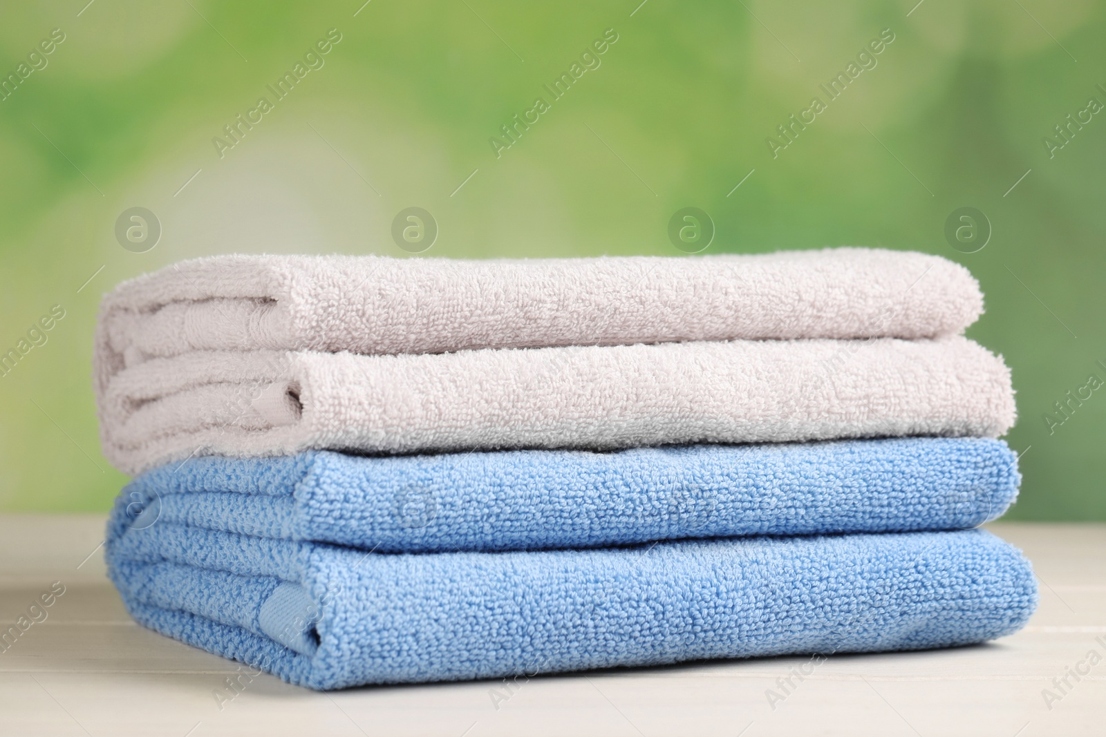 Photo of Soft folded towels on white wooden table