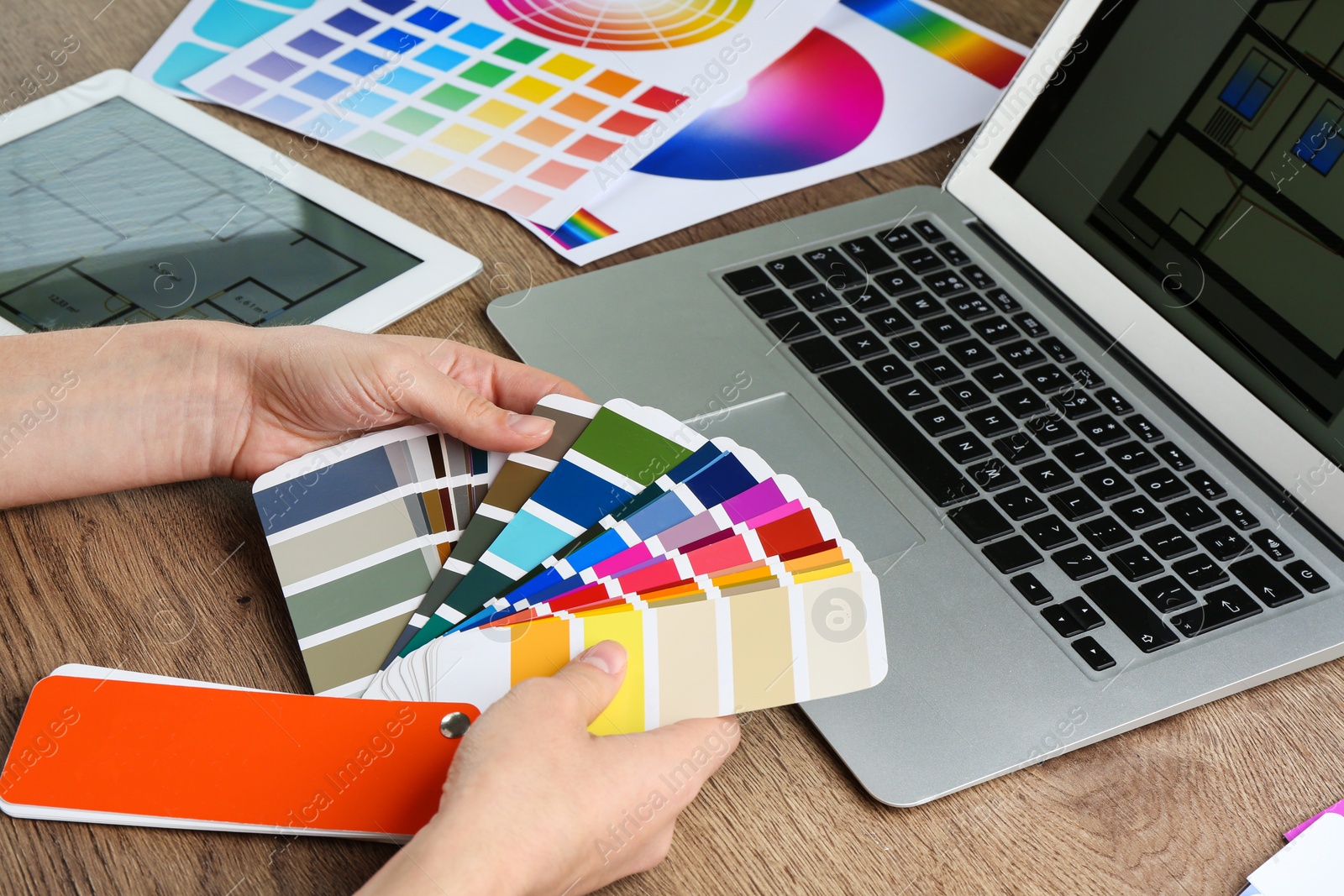 Photo of Woman with palette samples at wooden table, closeup