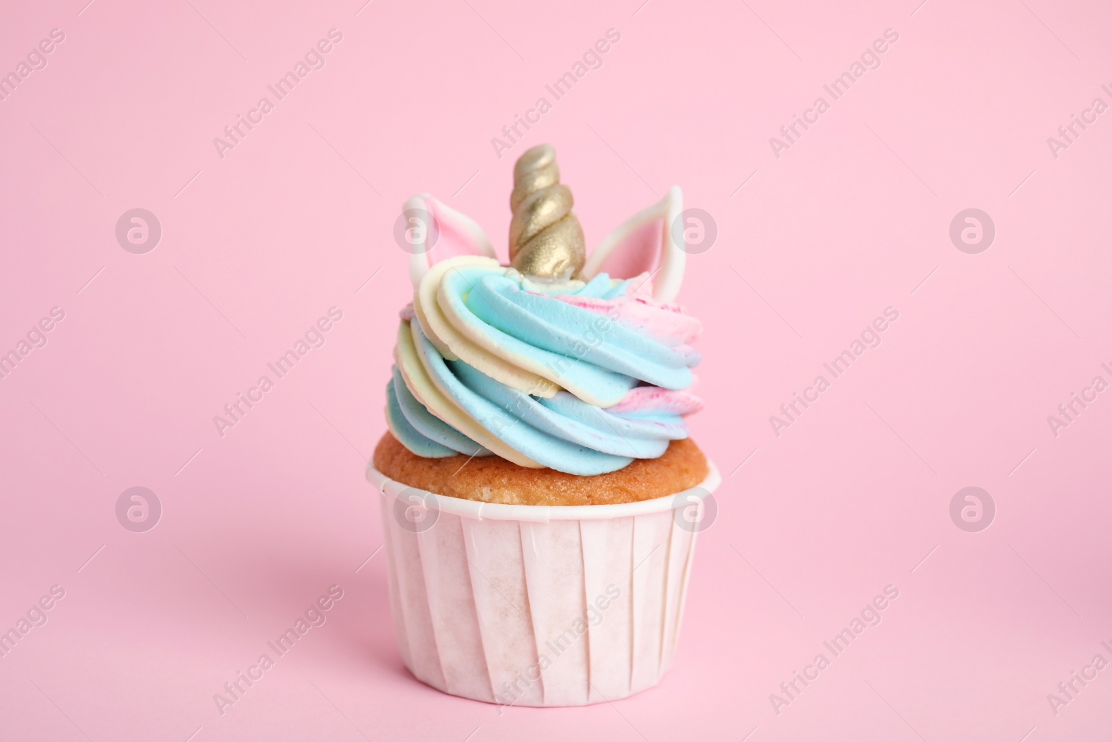 Photo of Cute sweet unicorn cupcake on pink background