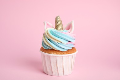 Cute sweet unicorn cupcake on pink background