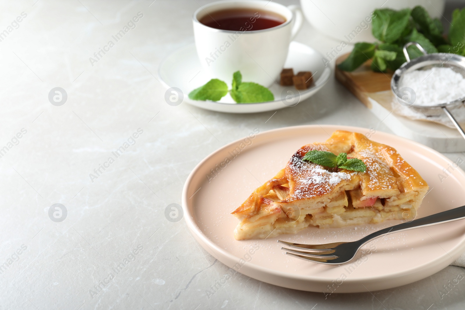 Photo of Slice of traditional apple pie served on light marble table. Space for text