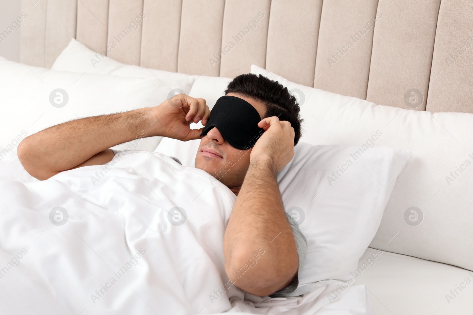 Photo of Man wearing sleeping mask in bed at home