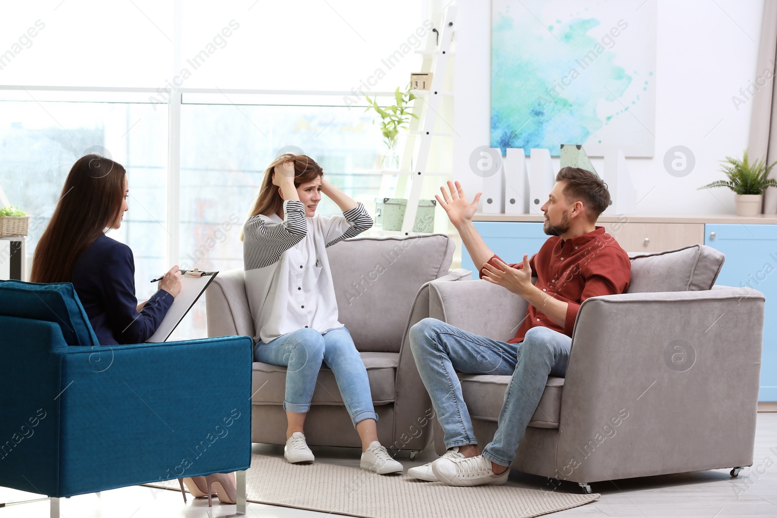 Photo of Family psychologist working with young couple in office