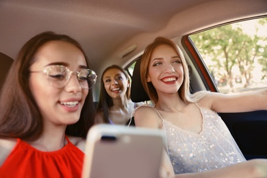 Happy beautiful young women together in car